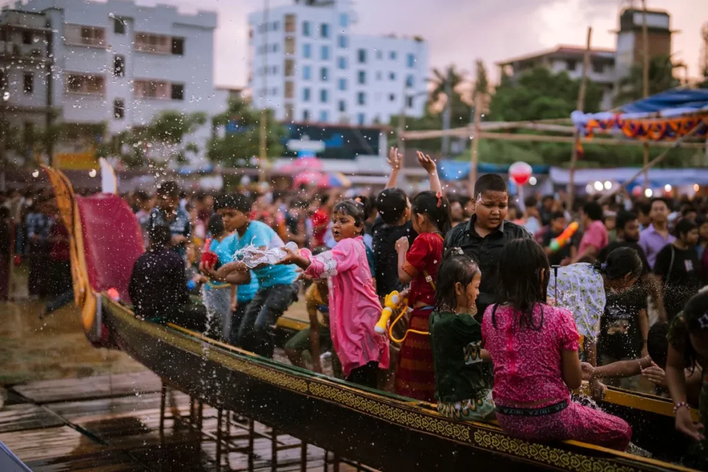 Kinderen kijken bij de haven naar een boot tijdens een feestelijke intocht