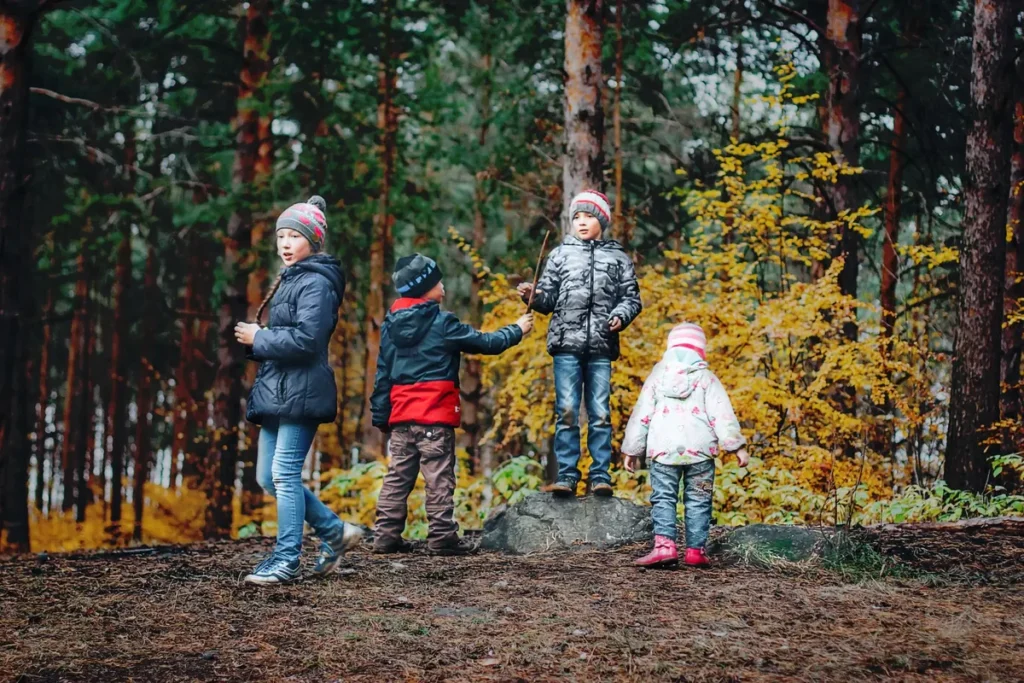 Kinderen spelen met takken in een speelbos