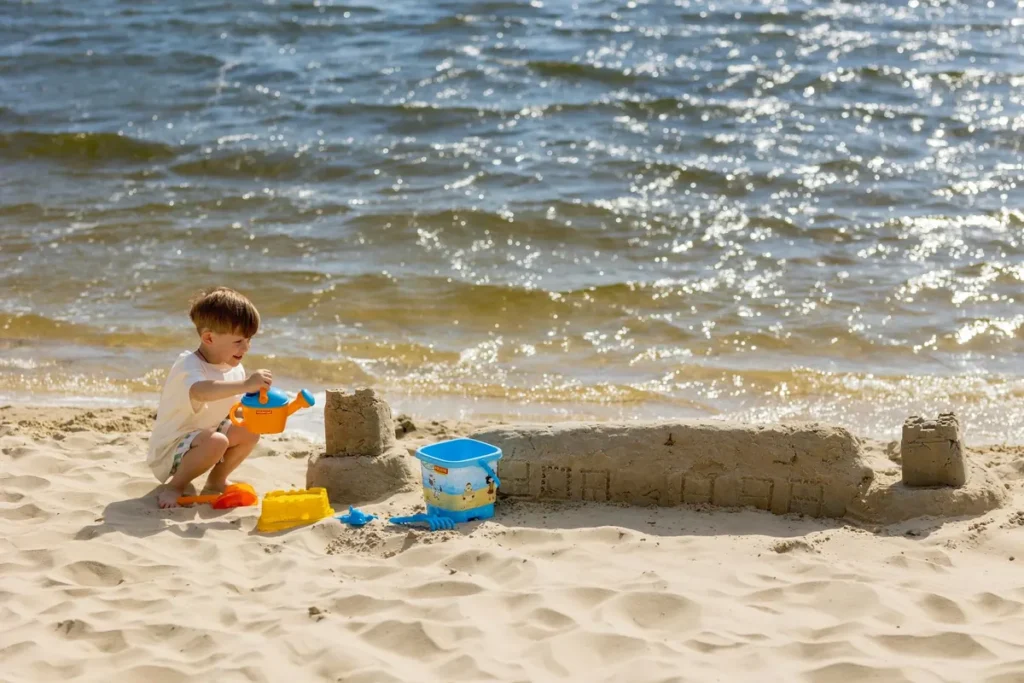Peuter bouwt een zandkasteel op het strand