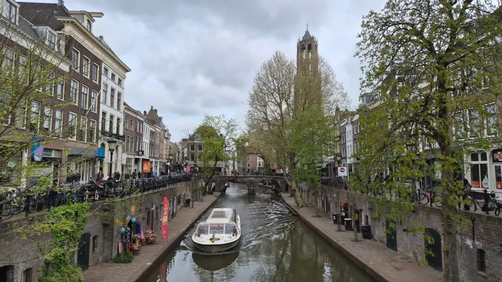 Rondvaartboot op een gracht met terrassen op de werven