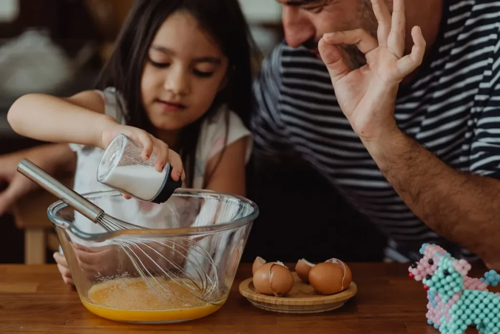 Vader en kind die samen deeg kneden in de keuken